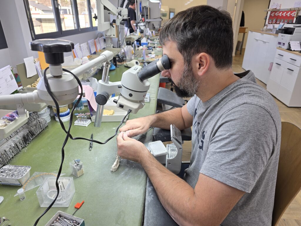 Benjamin Janki gliema e fuorma cun agid dil microscop in dent.