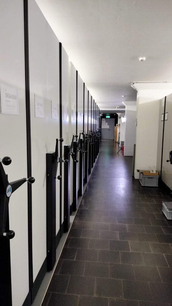 l tschaler dal museum da communicaziun a Berna ha plazza per blers stgazis. Actualmain èn radund in mez milliun objects magasinads en quest depot.  Olivia Portmann-Mosca