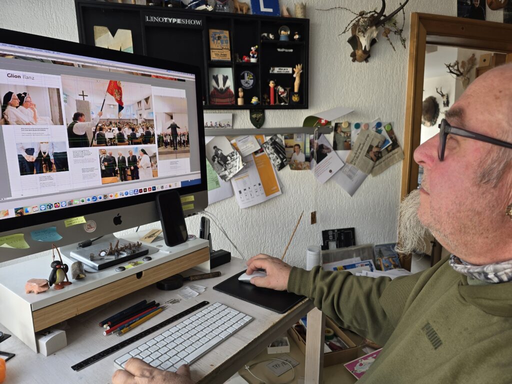 Il creader e poligraf al monitur. El lavura cun in Macintosh.