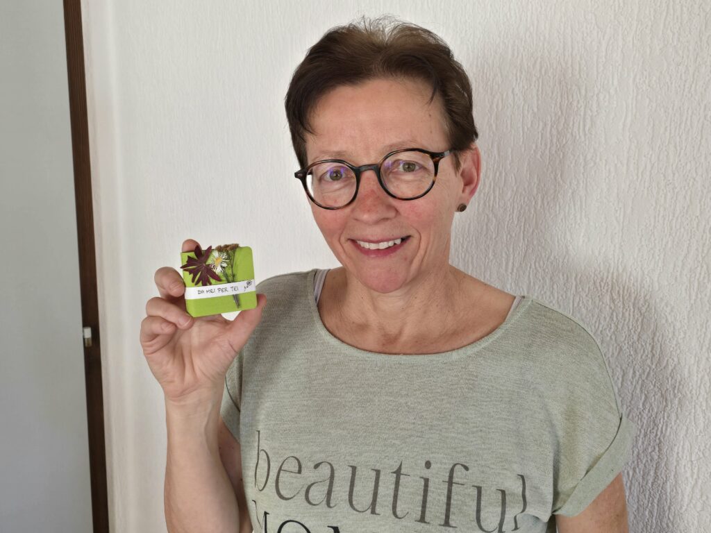 Maria Cavelti muossa in dils cudischets el format 5x5x2 centimeters.