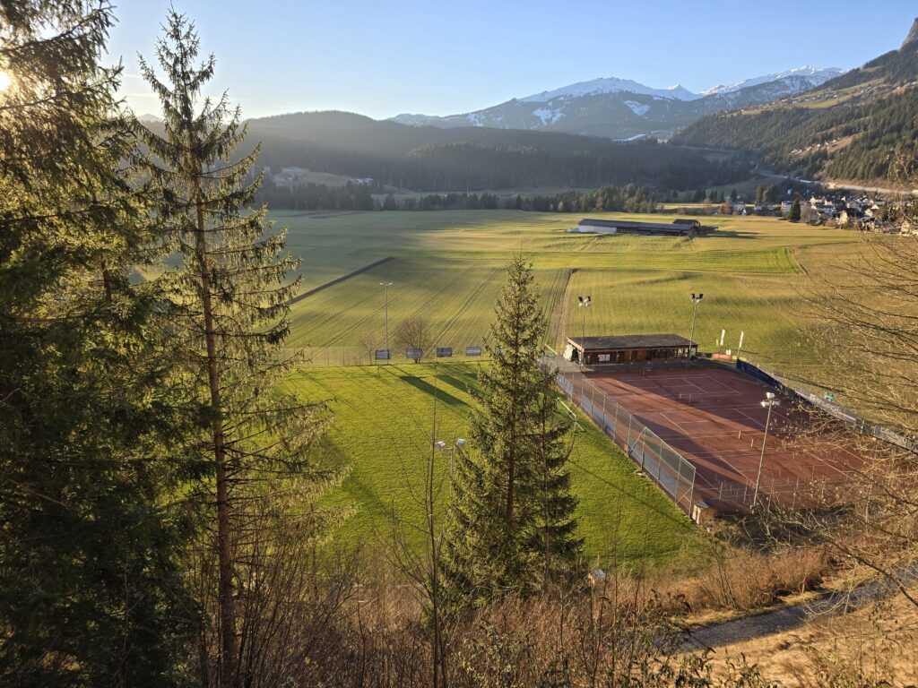 Vesta silla plazza da ballapei, dretg gl’implont da tennis. Davostier il Crap Sogn Gion.