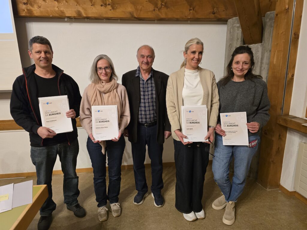 Vitus Dermont, il president dalla vischnaunca burgheisa da Laax, circumdaus dallas novas persunas ch'ein burgheisas dil liug.