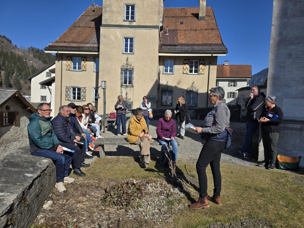 Avon l'entrada dalla baselgia reformada teidlan participontas e participonts dalla guidada il tuchiez imposant dalla baselgia s. Margreta.